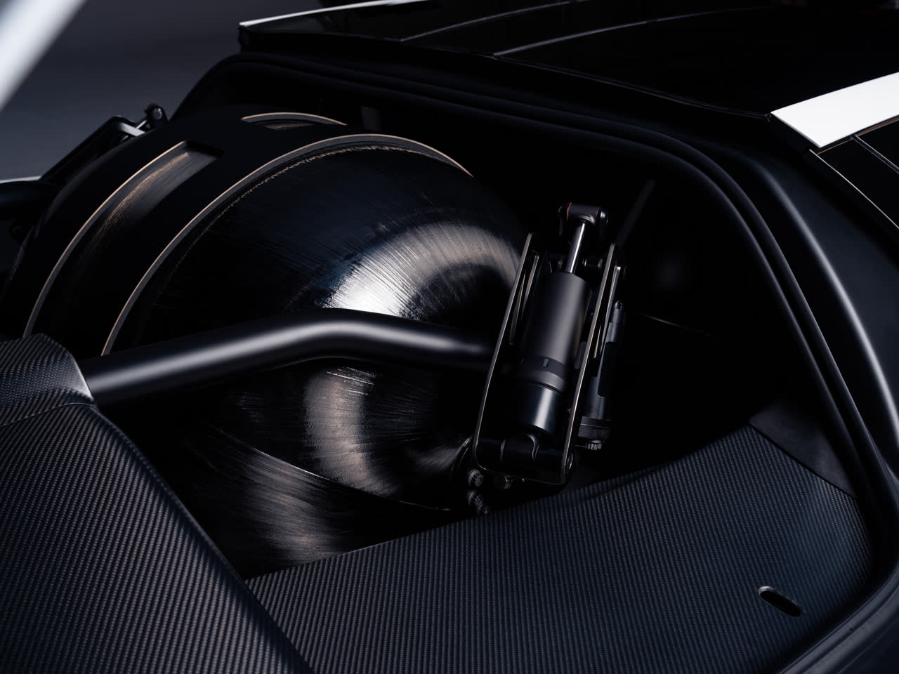 Close-up van een carbon drukvat en actuator achter het wiel van de Tesla Roadster